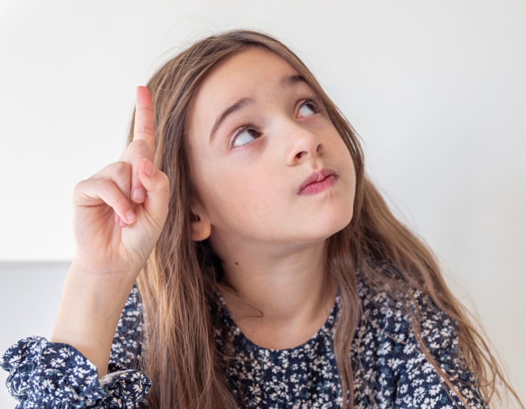 Potenciar el pensamiento crítico. Niña pensando con el dedo levanto y volteando hacia arriba.