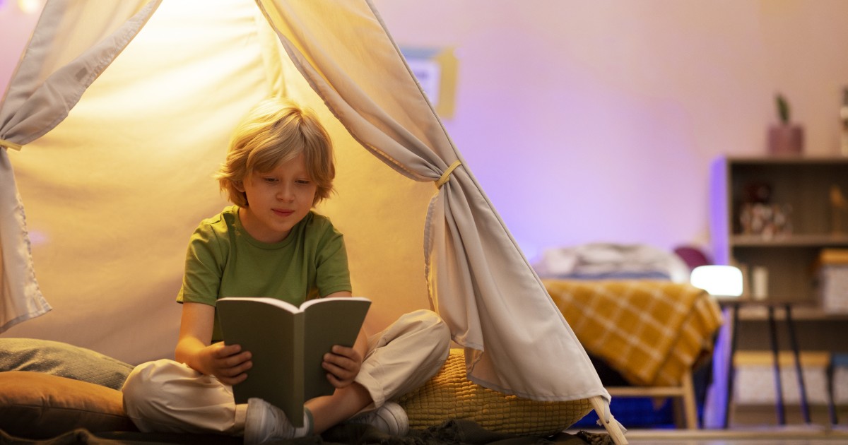 Tipos de lectores. Niño de 6–10 años leyendo un libro en casa, con expresión concentrada o de descubrimiento.